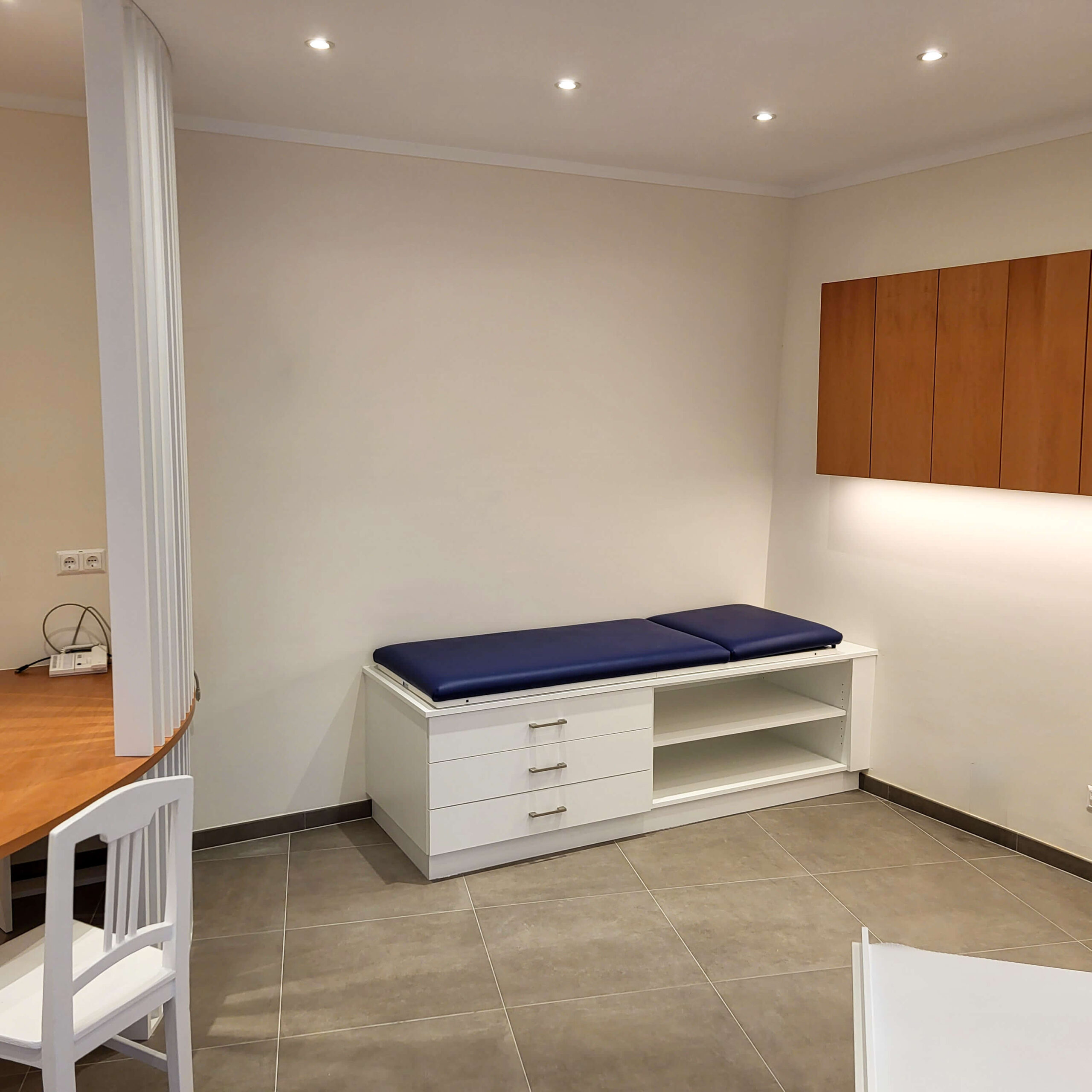 Arztpraxis, Behandlungsraum, Liege, Schreibtisch, Oberschränke, Schubladenelemente,