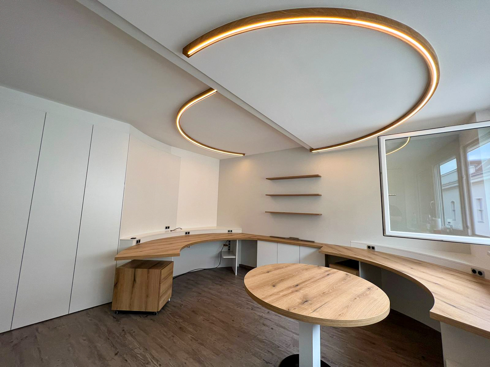 Büro, abgerundete Schreibtische, runder Besprechungstisch, beleuchtetes Deckenelement