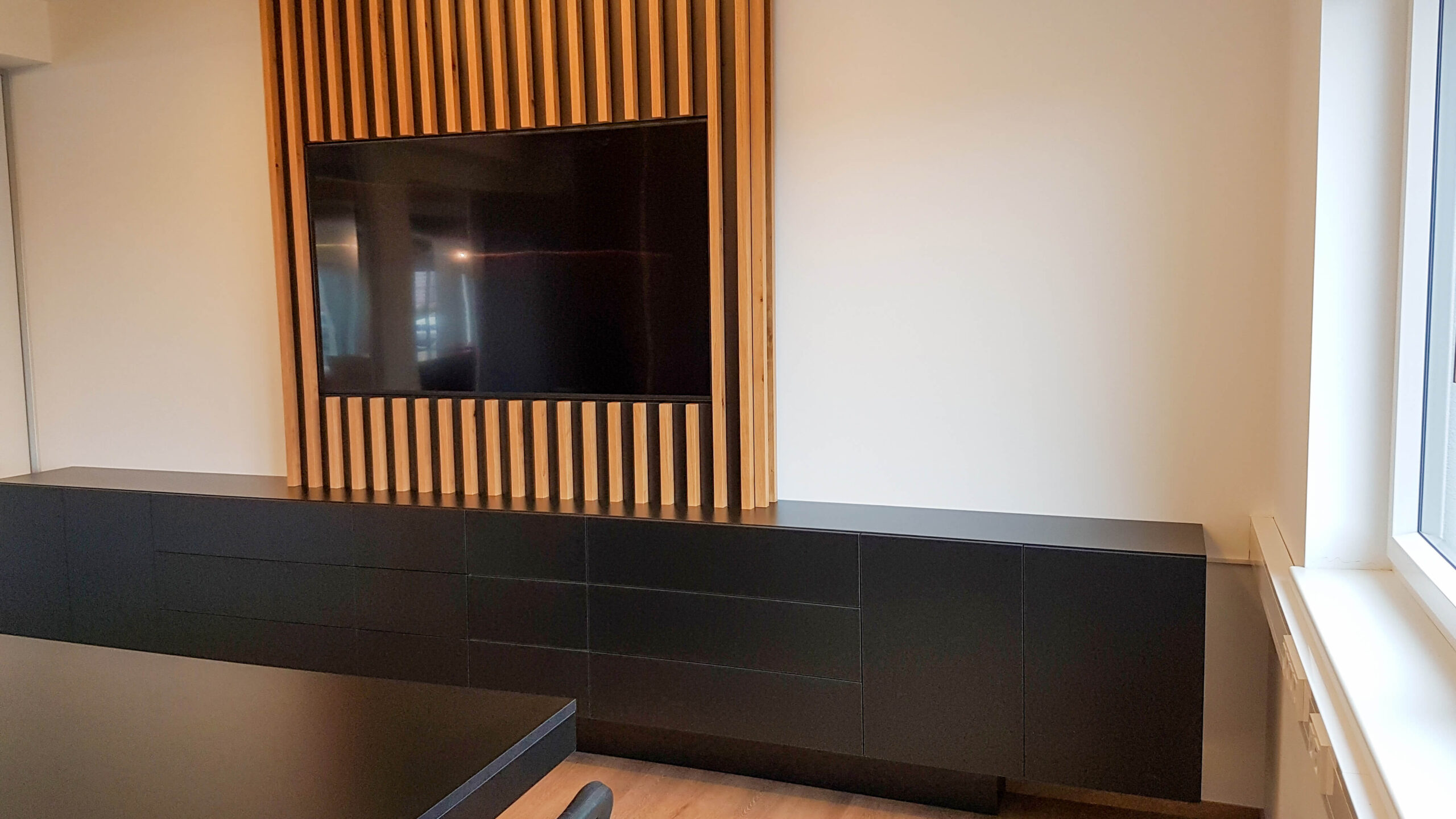 Besprechungszimmer, Kommode, Besprechungstisch in schwarz, Holzpaneele Wand, TV