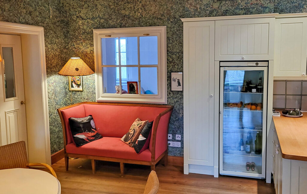 Küche Landhausstil mit ausgefallenere Tapete, rote Couch