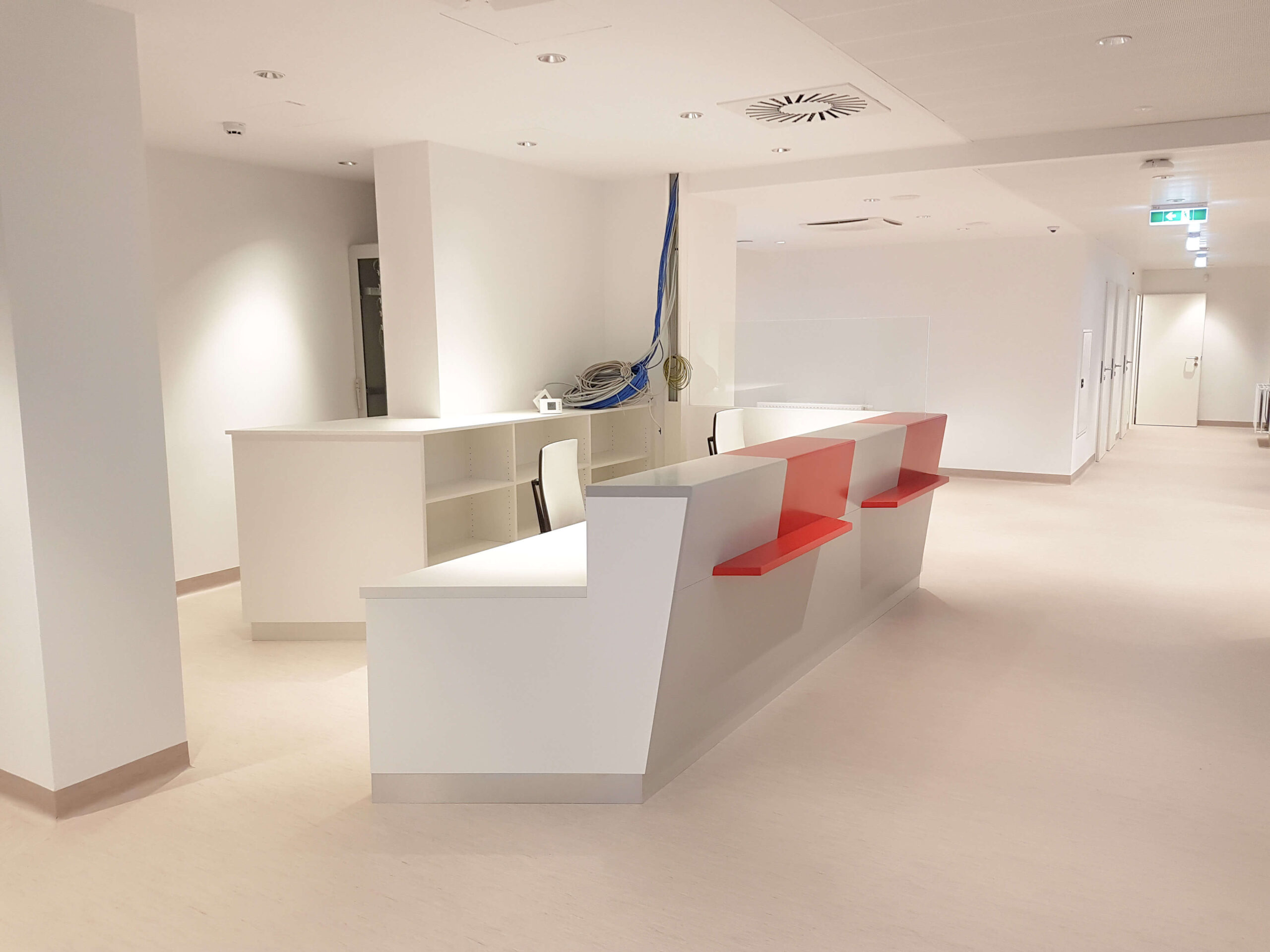 Empfangstheke weiß mit roten Elemente in Bürogebäude
