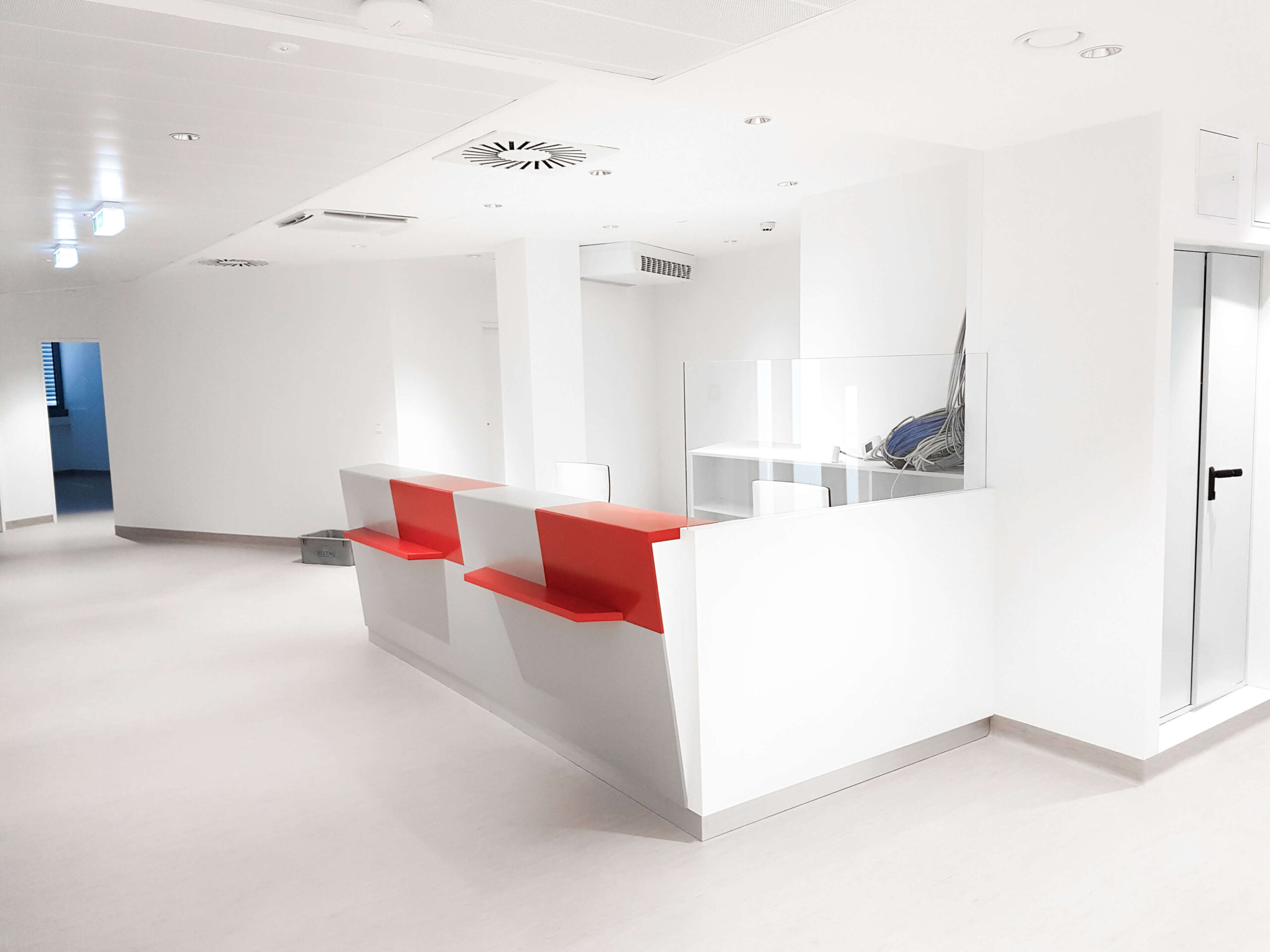 Empfangstheke weiß mit roten Elemente in Bürogebäude