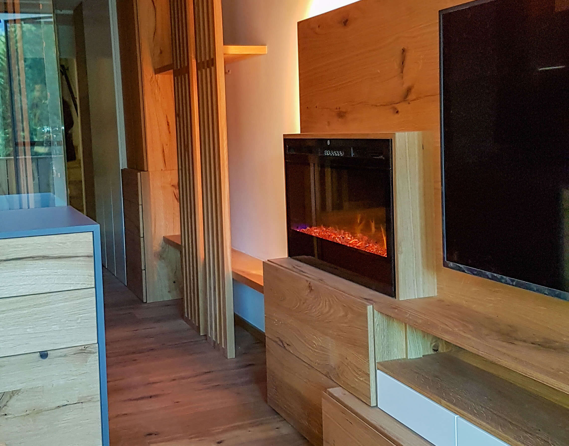 Blick ind den Gang einer Ferienwohnung, elektrischer Kamin, Holzgarderobe, Schränke