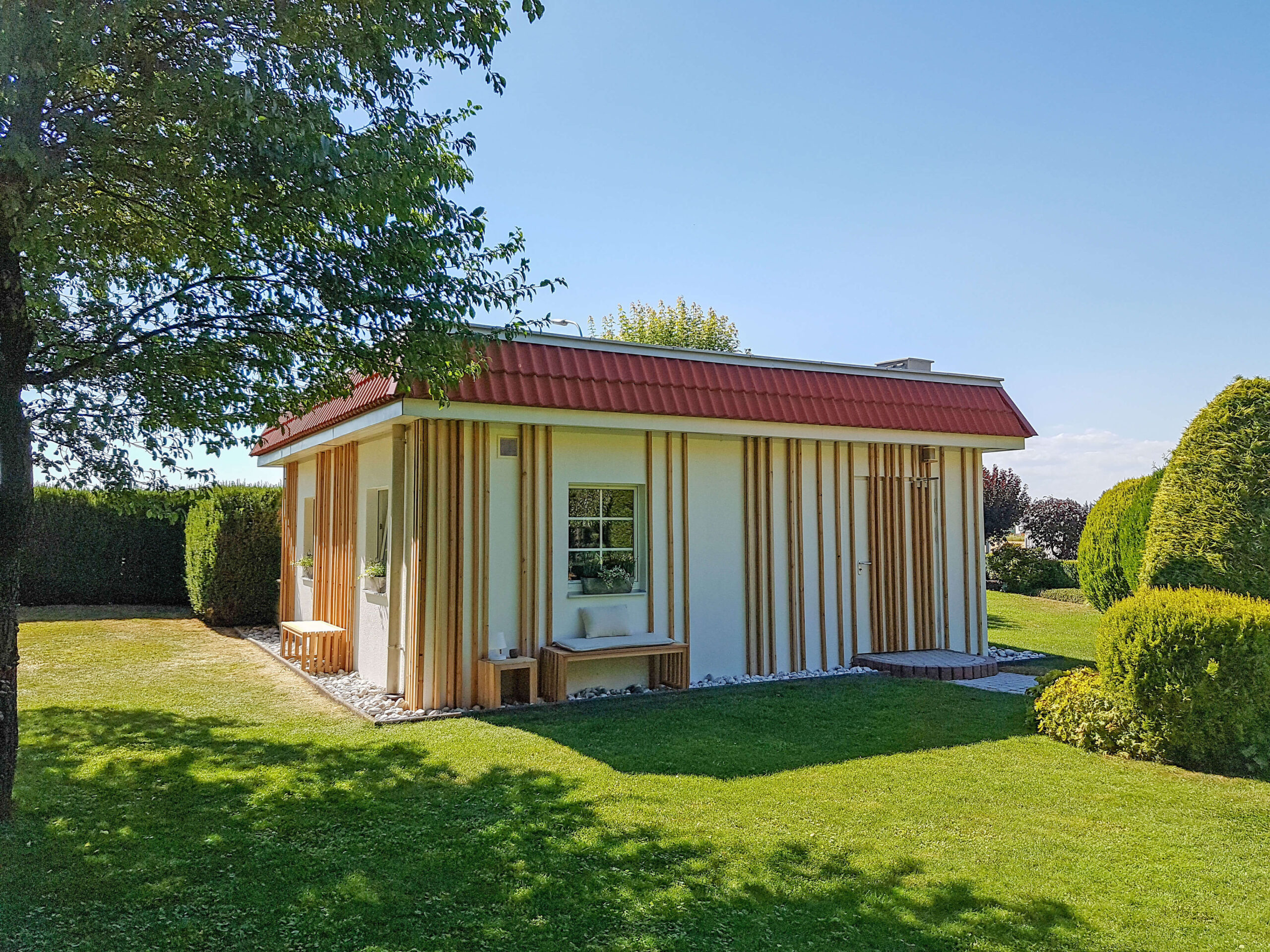 Gartenhaus, Holzpaneele an der Wand, Sitzbank und Hocker
