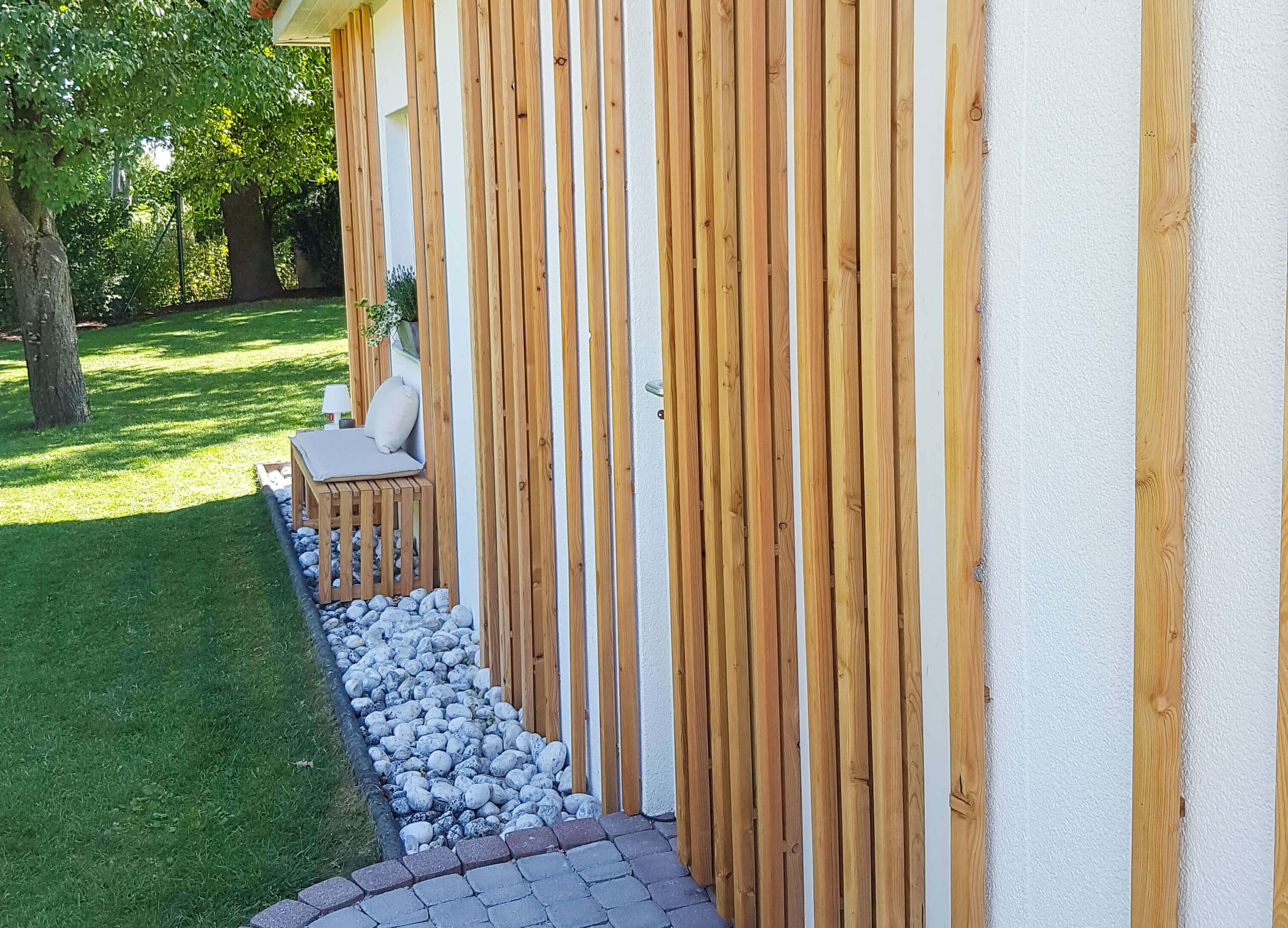 Gartenhaus, Holzpaneele an der Wand, Sitzbank und Hocker