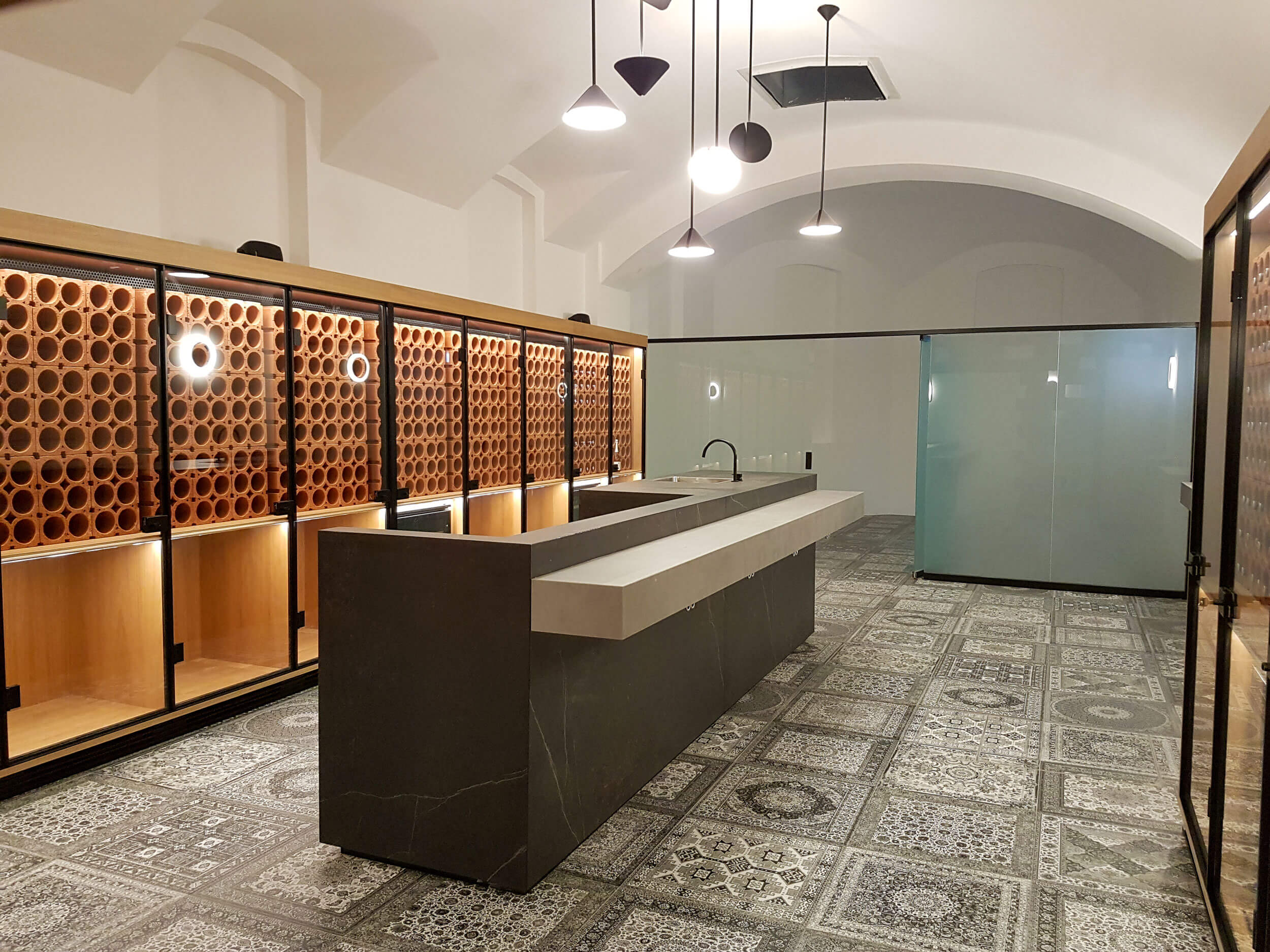 Weinverkostraum mit Design-Holzelementen Theke in der Mitte aus Stein, Kühlschränke für Weinflaschen, Glasschiebetür