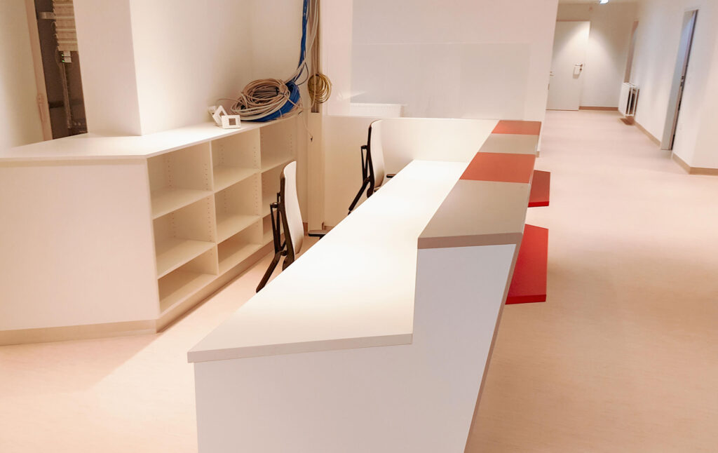 Empfangstheke weiß mit roten Elemente in Bürogebäude