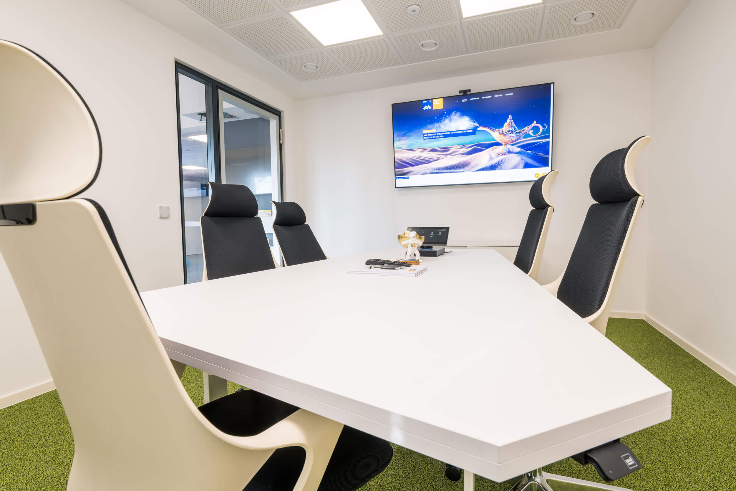 Besprechungszimmer großer Tisch, Drehsessel, Fernseher an der Wand