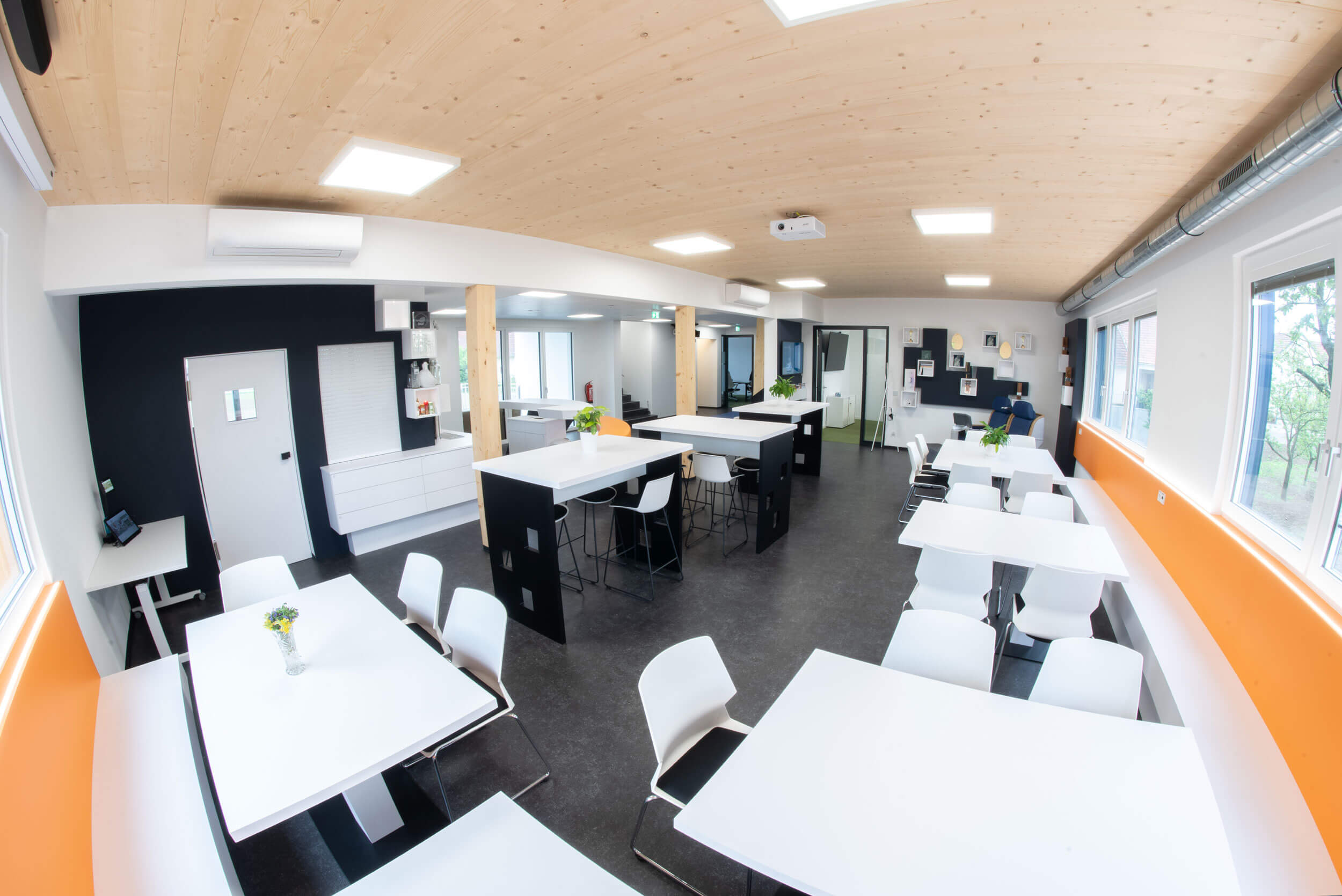 Essbereich Bürogebäude, viele Tische und Sessel, durchgehende Bank